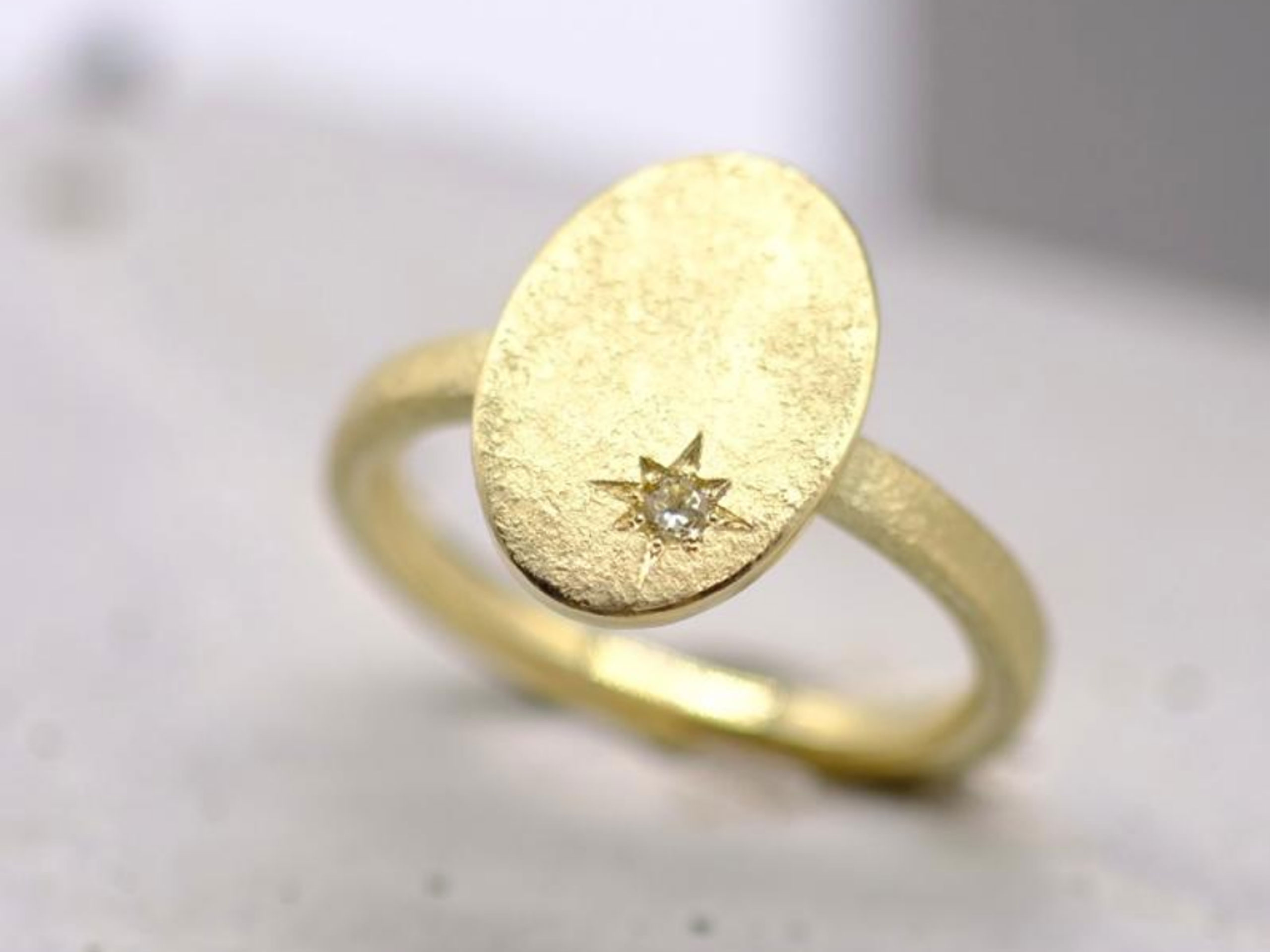 Goldener Ring mit Stern und Stein